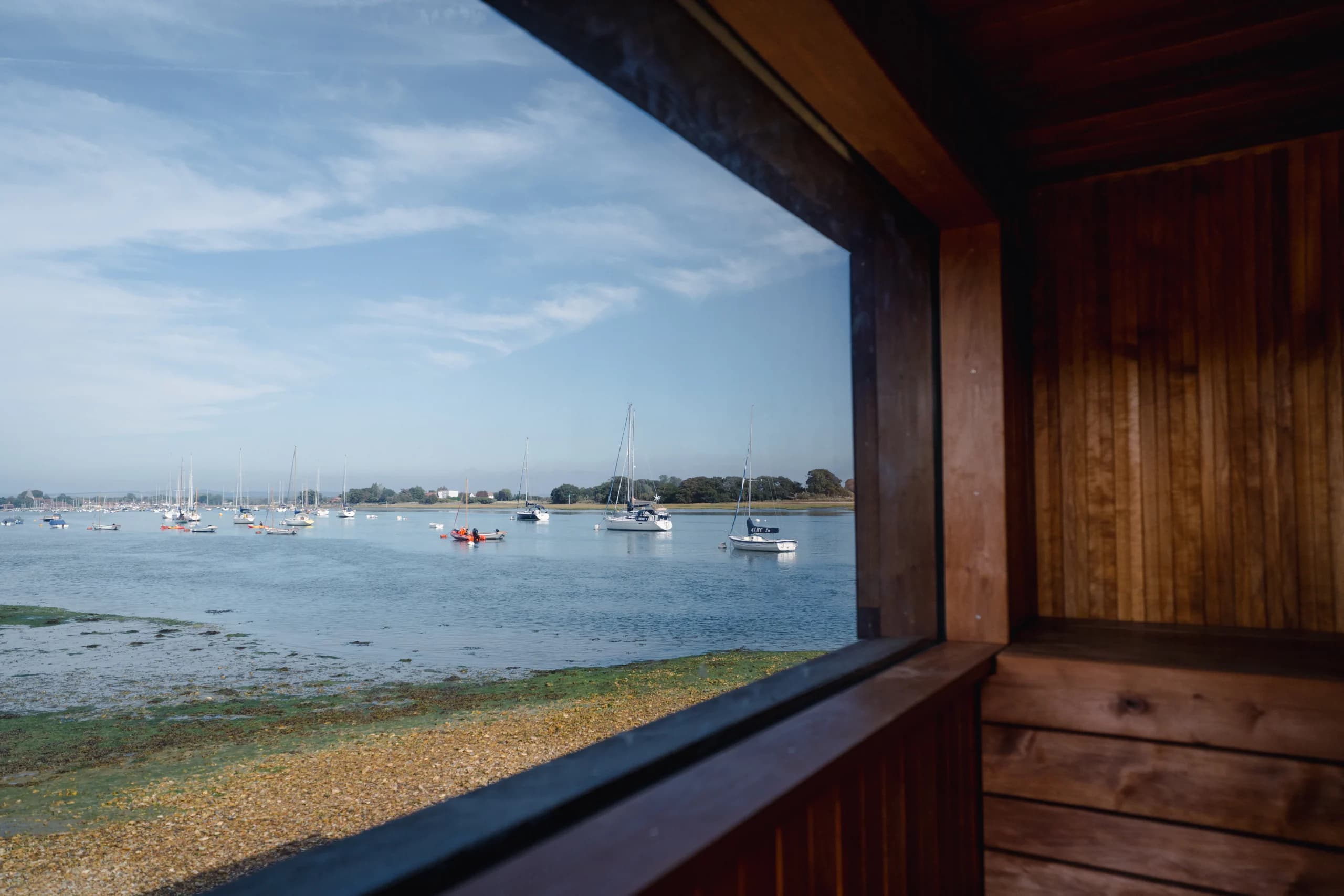 The view from the Bosham Sauna porch across the harbour, with sailing boats moored at low tide.
